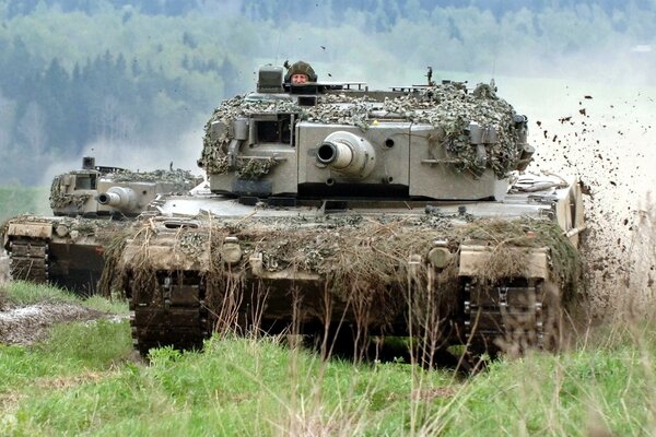 A camouflaged tank against the background of nature