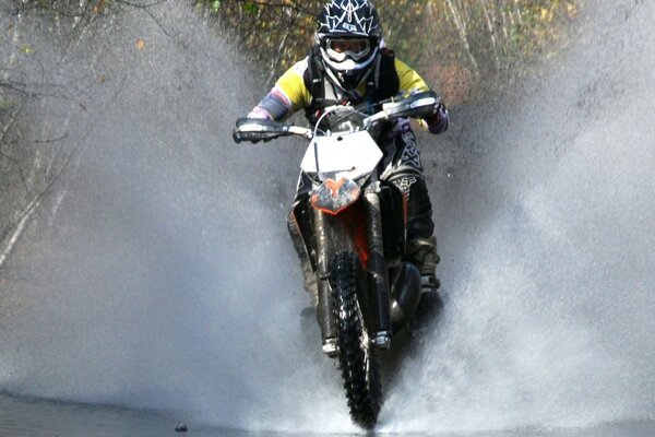 Motorradfahrer springt über Wasser