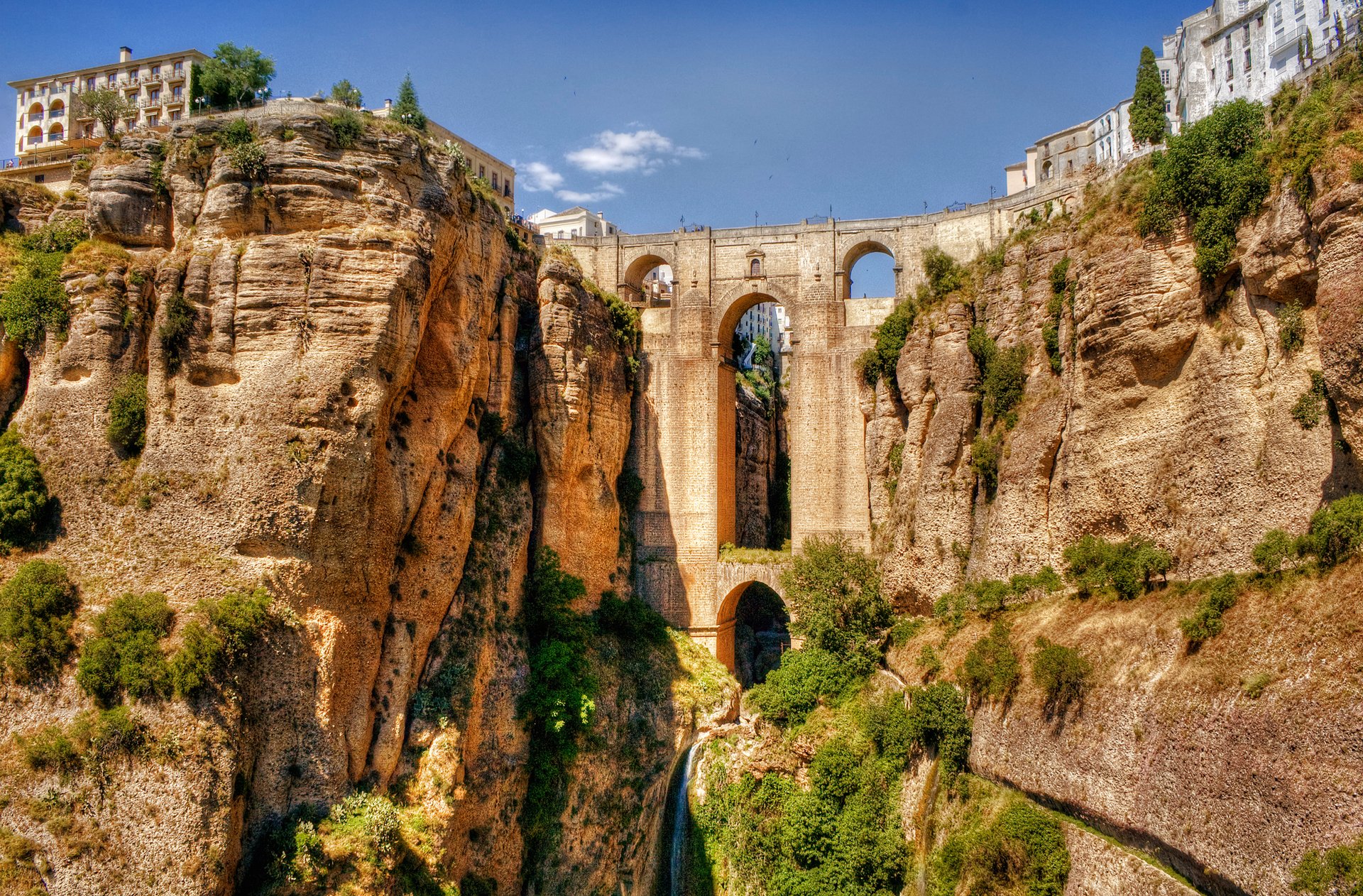 ronda andaluzja hiszpania akwedukt most łuk skała domy niebo rzeka krzewy