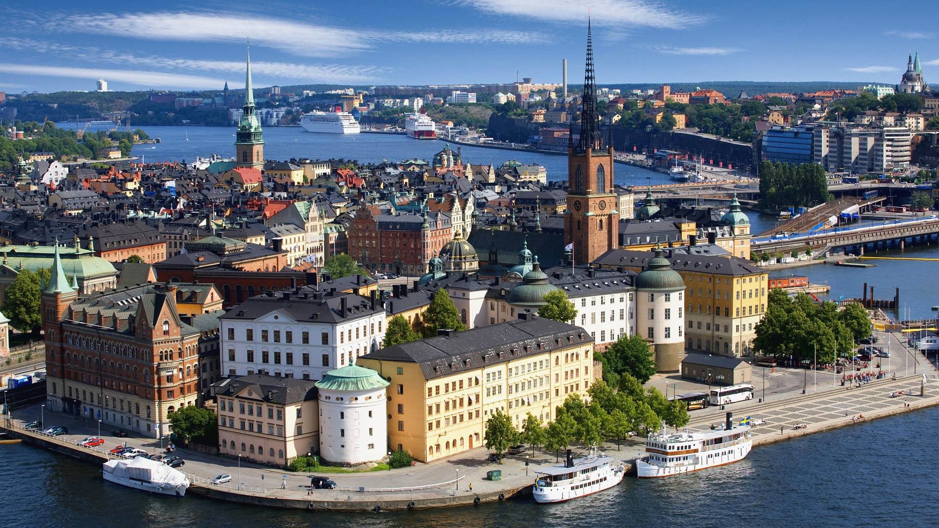 skandynawia szwecja sztokholm kościół riddarholmen rzeka morze liniowiec statek port domy wieża iglica niebo chmury most