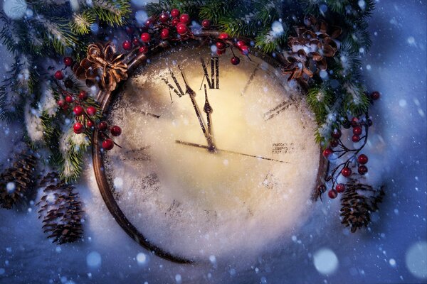 Orologio di Capodanno nella neve e rami di abete rosso