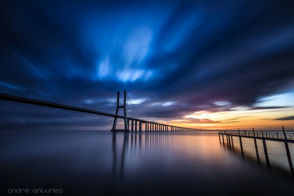 Bridge over the river under the bright evening sky