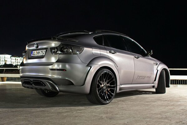 Silver BMW on the bridge at night