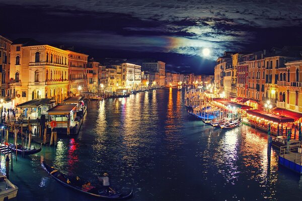 Veneci, Italia. Góndolas y barcos en luces nocturnas