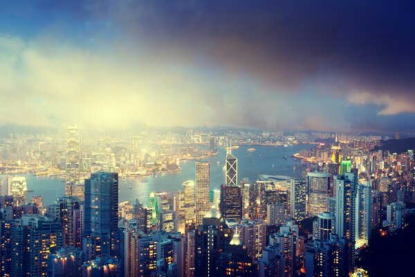 Panorama de Hong Kong: río, nubes y edificios altos contra el cielo nocturno