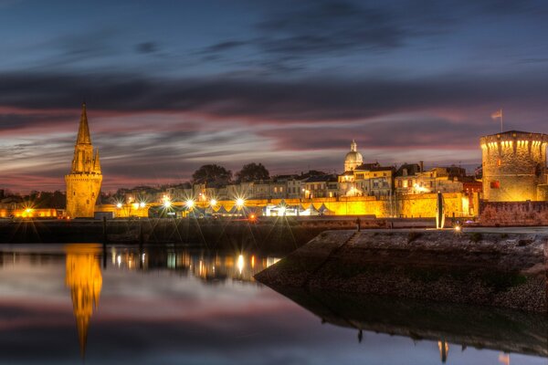 The river embankment in La Rochelle flooded with evening lights