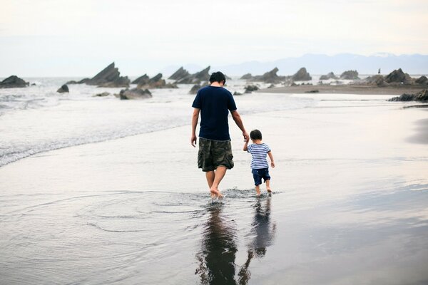 Семья на прогулке по пляжу. Отец и сын