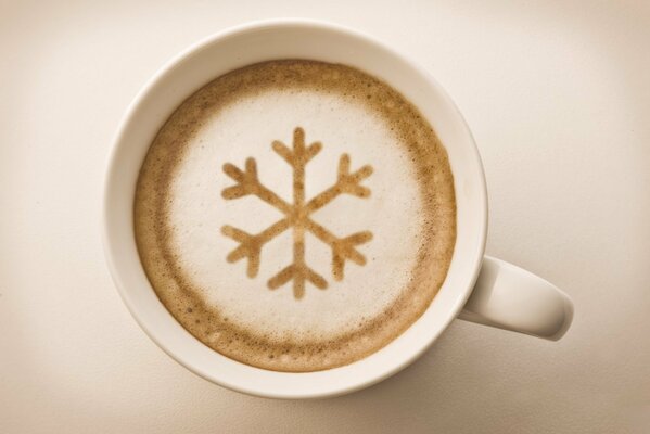 Cappuccino avec motif de flocon de neige dans une tasse blanche avec