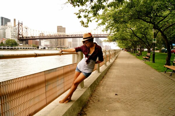 A girl on the embankment of the river walks