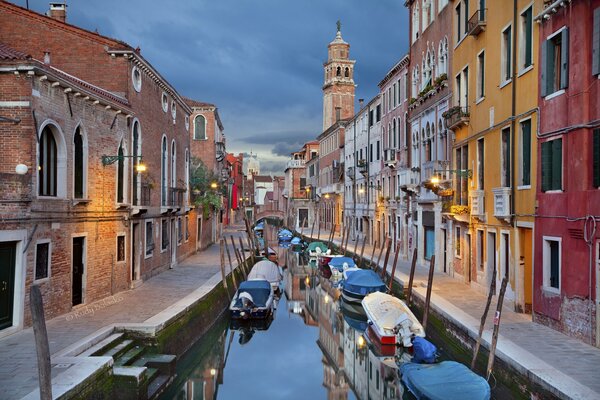 Stretto canale con barca e Venezia