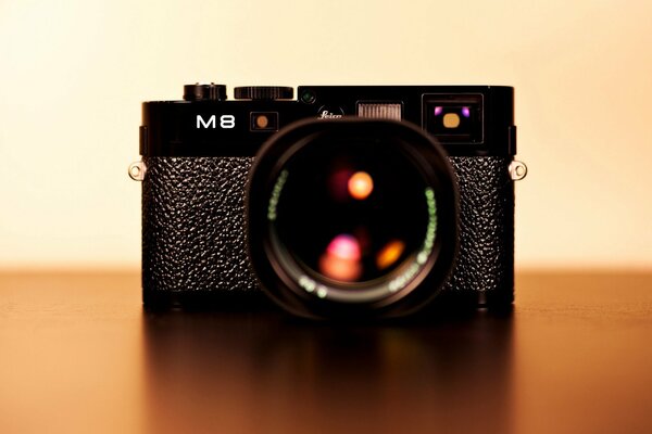 Черный фотоаппарат leica m8 с красивыми бликами в объективе