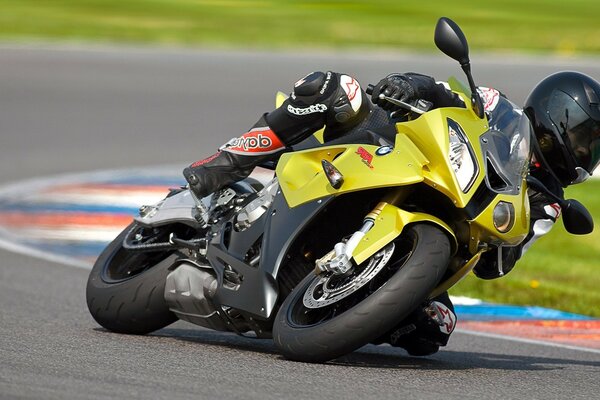 Motocicleta bmv S1000RR amarilla en fuerte repetición en pista