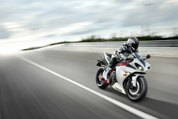 A motorcyclist rides along the highway on a motorcycle