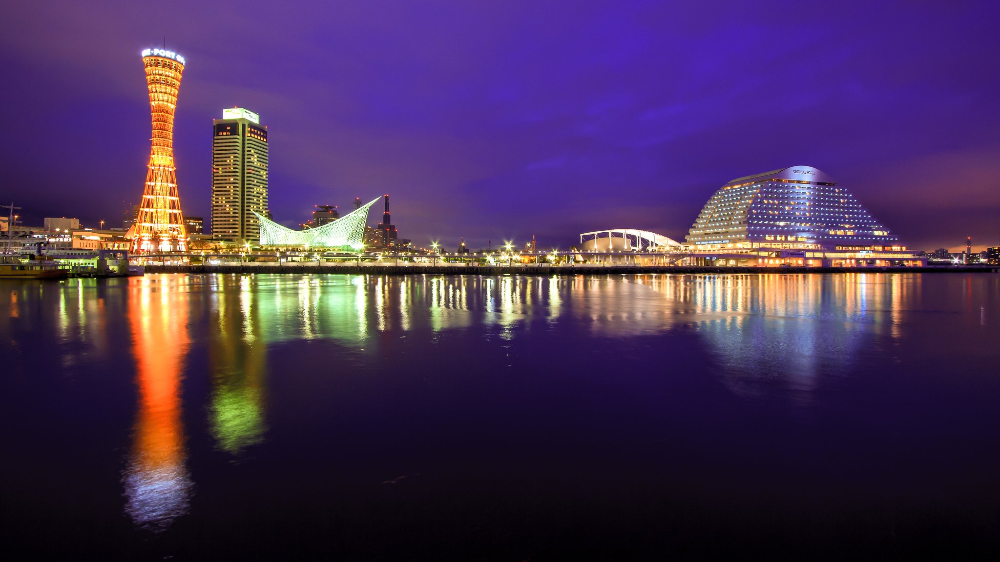 japón honshu kobe ciudad puerto estrecho edificios torre luces iluminación noche púrpura cielo