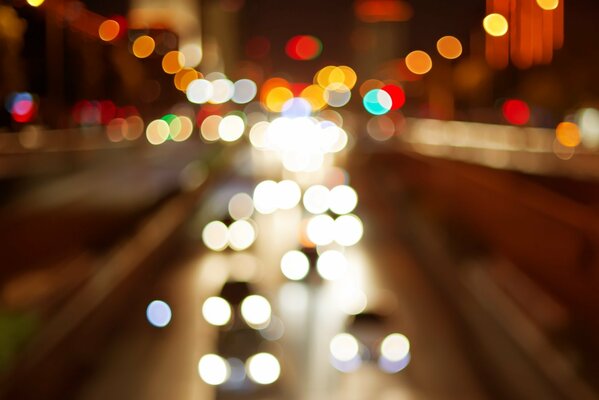 Les reflets des lumières des voitures des phares dans la rue de nuit