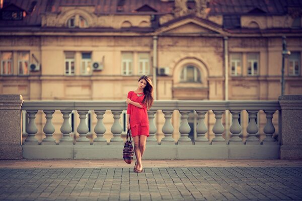 A girl in red walks the streets of Moscow