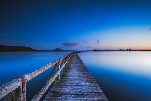 Puente a lo largo del lago al atardecer, paisaje