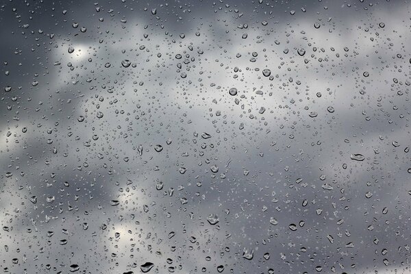 Bewölktes Wetter und Regentropfen auf Glas