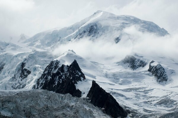 The top of a snowy mountain in the fog