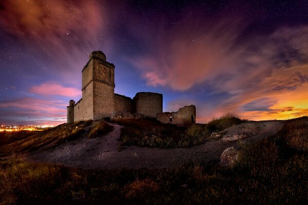 Stone castle on a hill under a fantastic sky