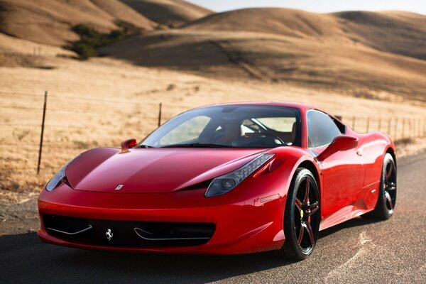 Une Ferrari rouge roule sur une route déserte