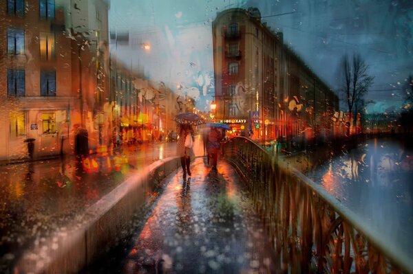 Deux filles avec des parapluies sur le pont sous la pluie