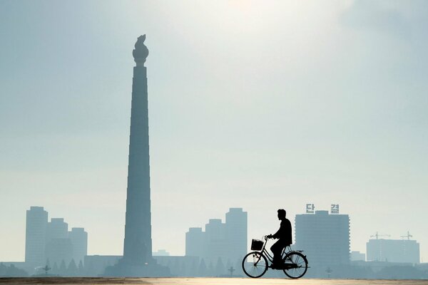 Hombre que pasa en bicicleta por la ciudad de Pyongyang
