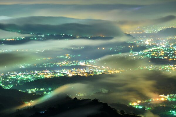 Vista delle luci della città nella nebbia di notte