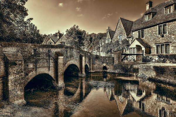 A processed castle in England across a bridge passing through a river