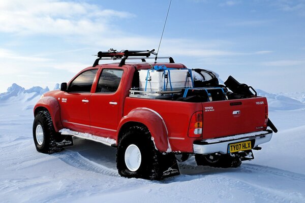 Potężny czerwony SUV toyota hilux na Biegunie Północnym