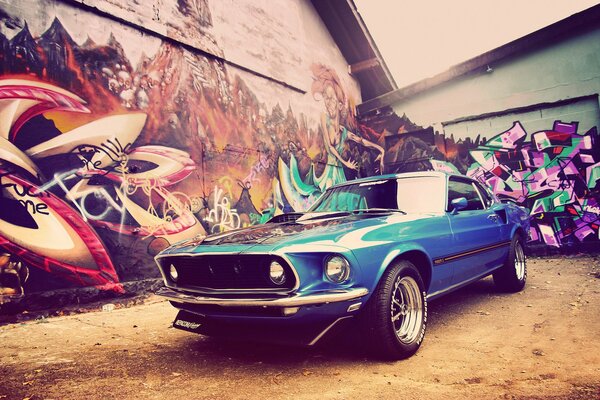 Mustang bleu de 1969 sur fond de mur avec graffiti