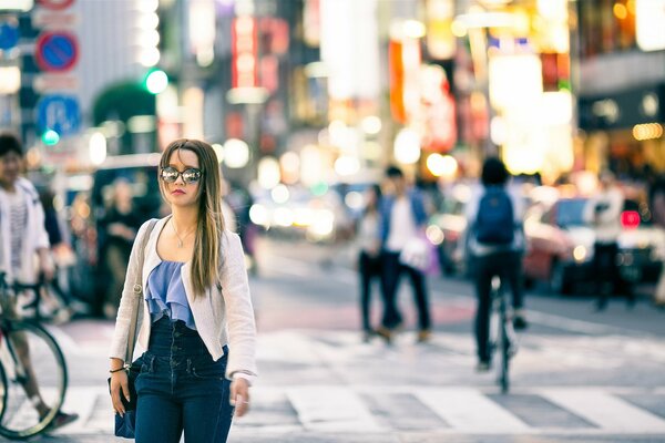 Strada traffico, passaggio pedonale ragazza con gli occhiali da sole, ciclisti