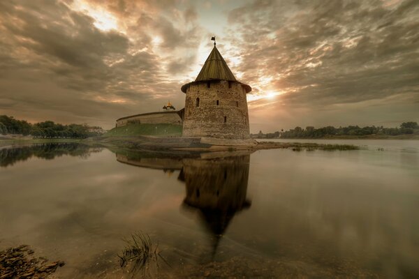 Amanecer que se refleja en el agua en otoño en Pskov