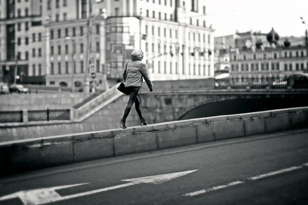 The girl walking on the edge of the bridge