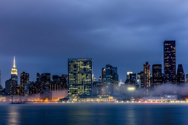 Evening lights of skyscrapers in the fog