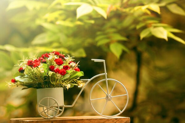 Ein Strauß heller Blumen in einem fahrradförmigen Korb