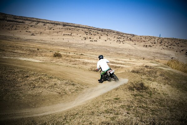 Motociclista su una moto che corre attraverso i campi e le foreste di sicuro alla sua signora da un villaggio vicino