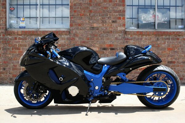 Black and blue sports motorcycle on a brick wall background