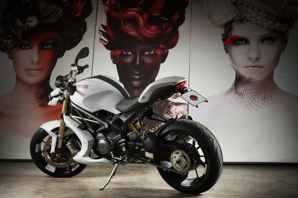 Moto ducati noir et blanc sur fond de femmes peintes