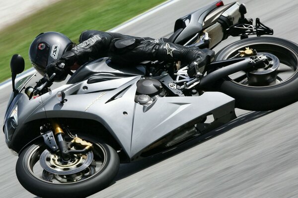 A gray bike with a motorcyclist came to a turn on the highway