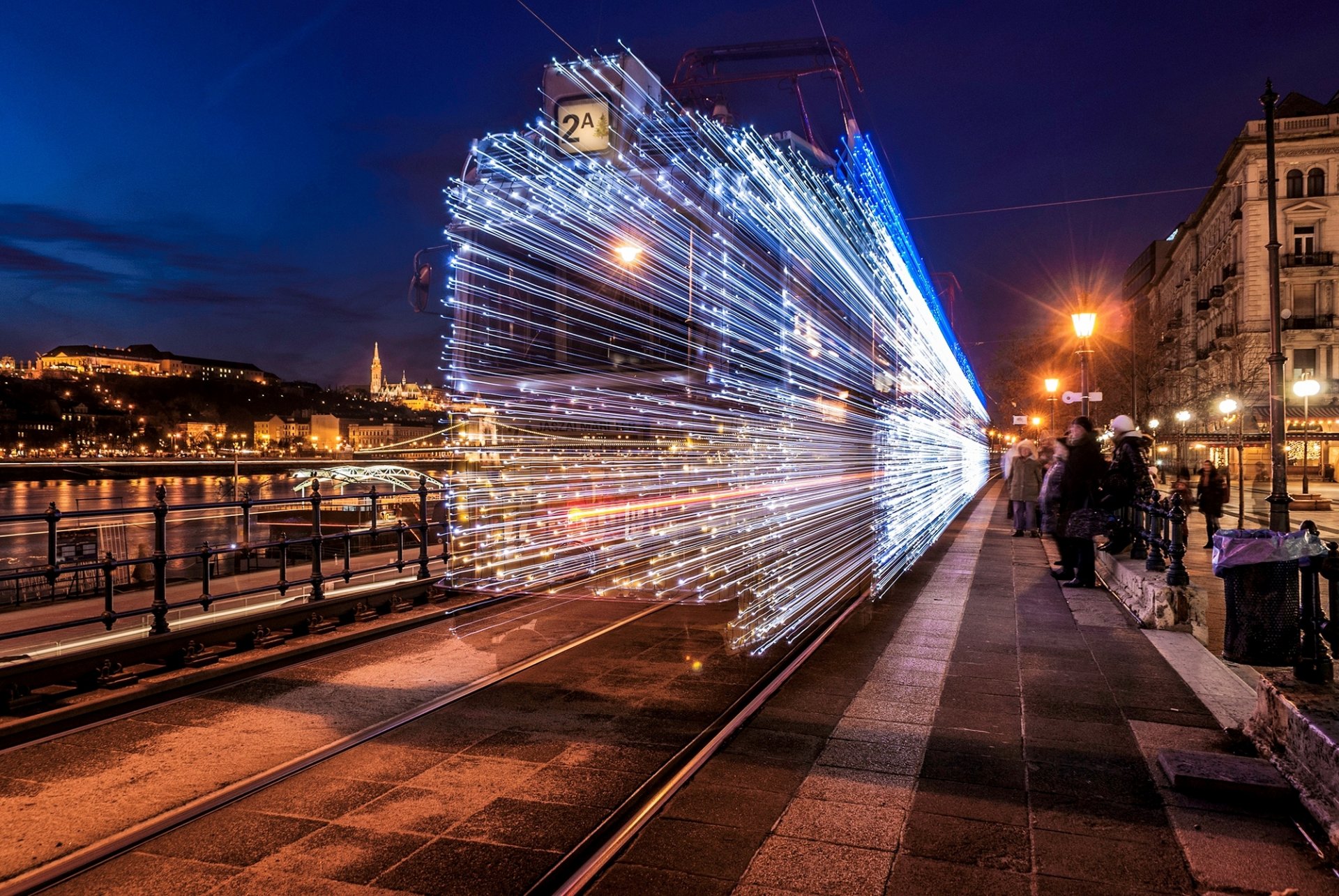 hongrie magyarország budapest ville nuit lumières guirlandes tram route rails arrêt personnes éclairage lanternes maisons bâtiments