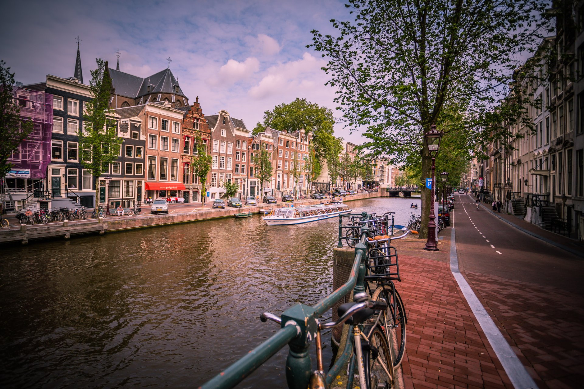 amsterdam city netherlands canal river houses road cars bicycles sidewalk