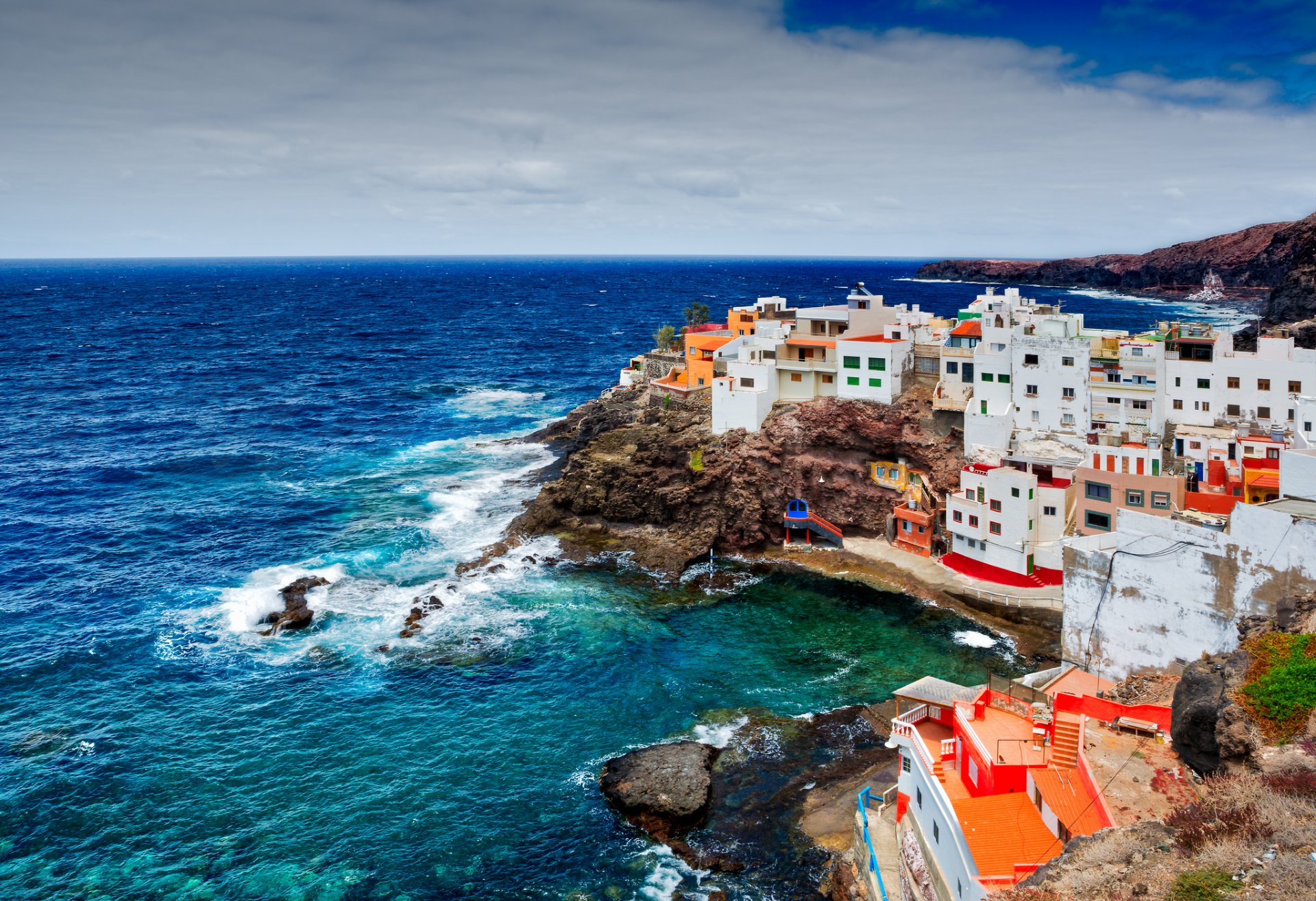 playa la caleta de arriba playa de caleta de arriba hiszpania las wysp kanaryjskich wyspy kanaryjskie ocean skały klify wybrzeże domy budynki natura pochmurno