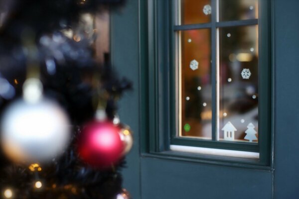 Weihnachtsspielzeug am Weihnachtsbaum in der Nähe des Hauses