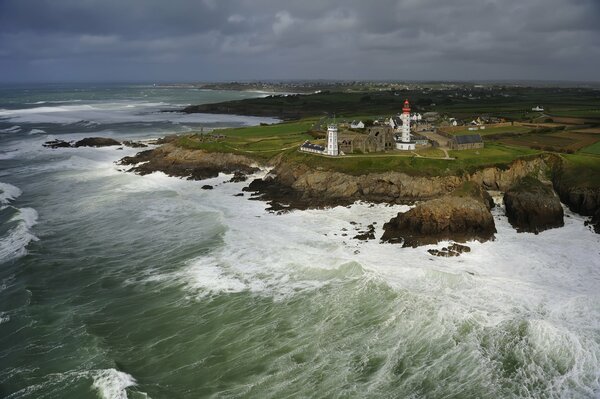 Vagues battant sur les rochers avec un phare