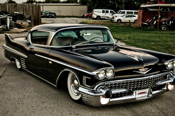 Black retro Cadillac on the background of other cars