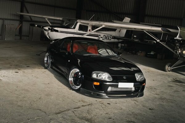 A black car on the background of an airplane