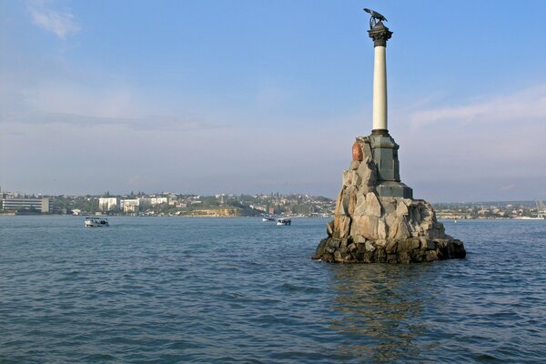 The hero city of Sevastopol, a monument to submerged ships, against the background of the seashore and the city