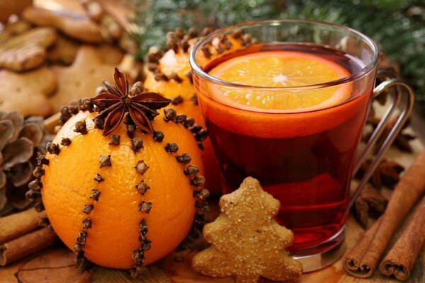 Ready-made mulled wine with an orange slice and an orange next to it