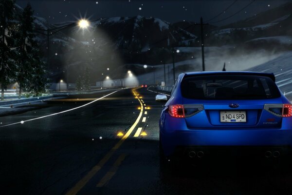 Niebieski Subaru na pustej nocnej drodze